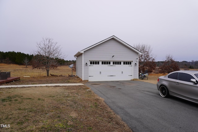 view of side of property with a garage, an outbuilding, and central air condition unit