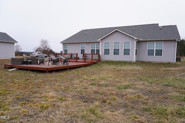 back of house with a wooden deck and a lawn