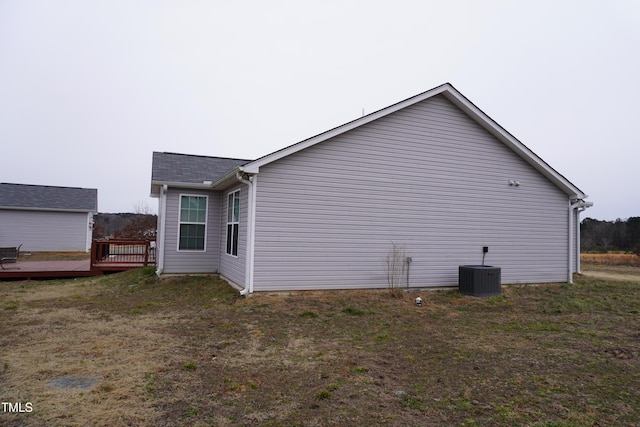 view of home's exterior featuring central AC, a wooden deck, and a yard