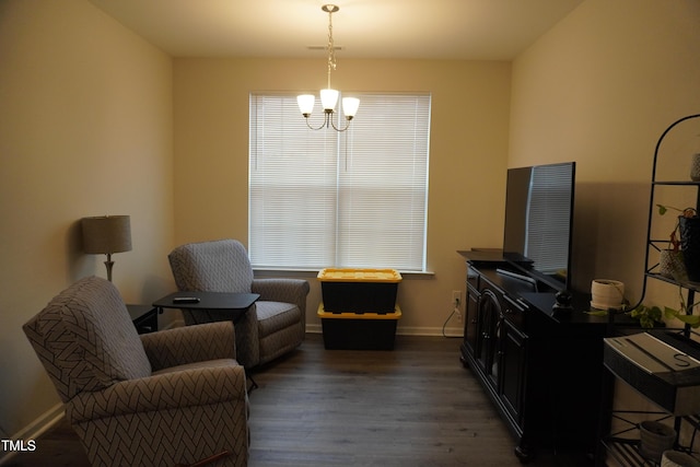 living area with dark hardwood / wood-style floors and an inviting chandelier