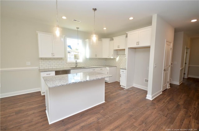 kitchen featuring dark hardwood / wood-style flooring, white cabinetry, sink, and a kitchen island