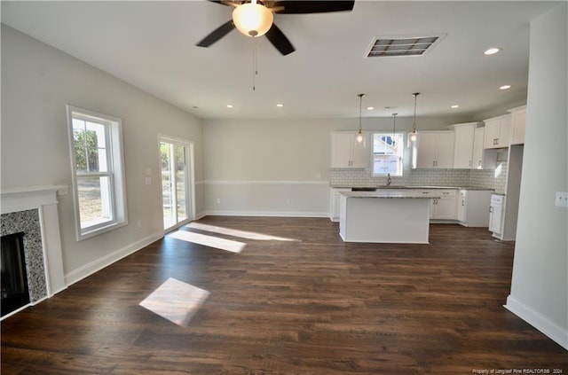 kitchen featuring tasteful backsplash, a center island, dark hardwood / wood-style flooring, white cabinetry, and pendant lighting