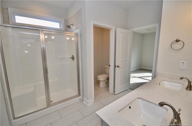 bathroom featuring toilet, an enclosed shower, vanity, and tile patterned floors