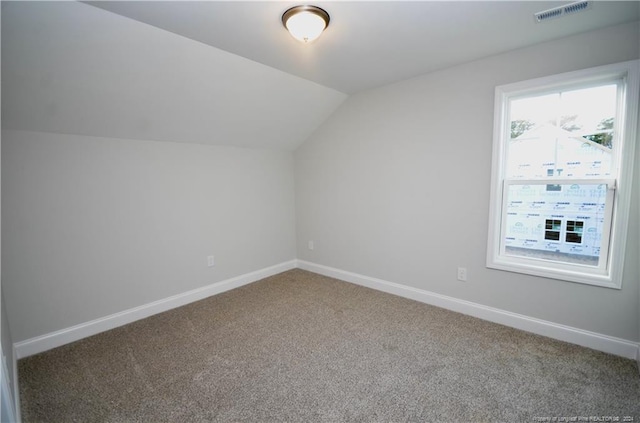 bonus room with vaulted ceiling and carpet flooring