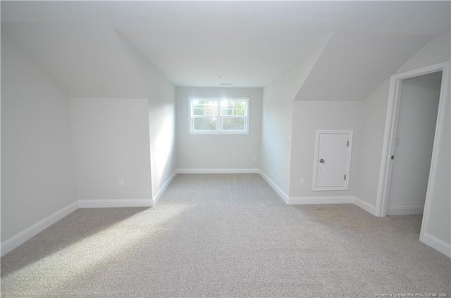 bonus room with light carpet and vaulted ceiling