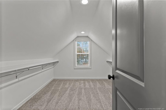 spacious closet with light carpet and vaulted ceiling