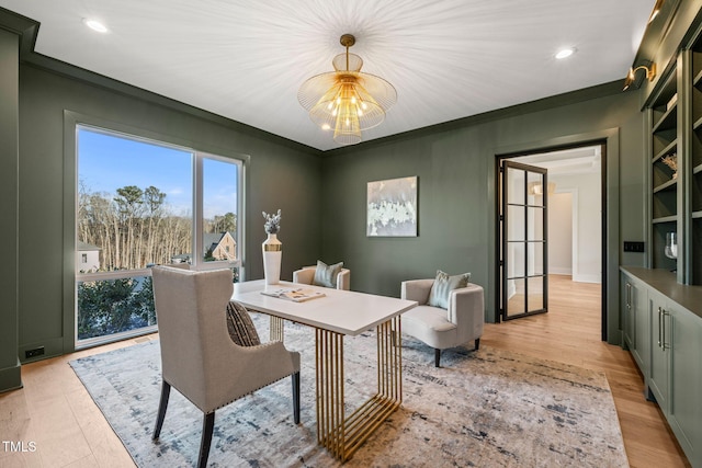 office with crown molding and light hardwood / wood-style floors