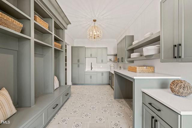 mudroom featuring ornamental molding, sink, and an inviting chandelier