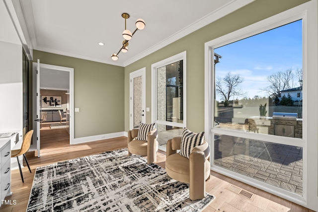 living area with crown molding and light hardwood / wood-style floors