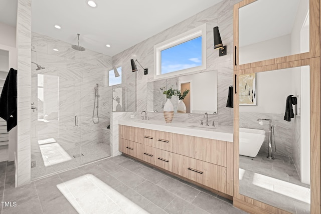 bathroom featuring independent shower and bath, vanity, and tile walls