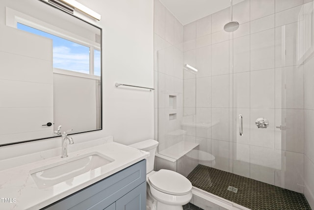 bathroom featuring vanity, an enclosed shower, and toilet