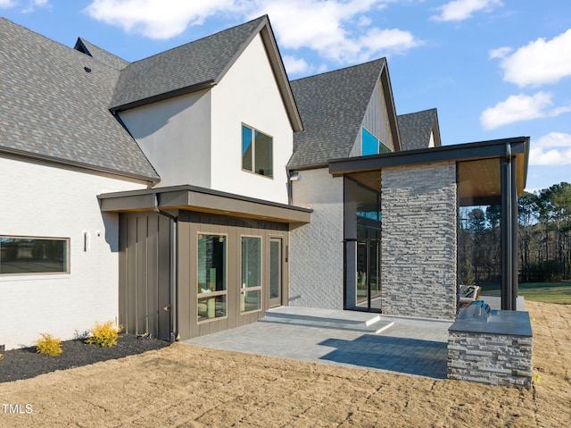 back of property featuring exterior kitchen and a patio