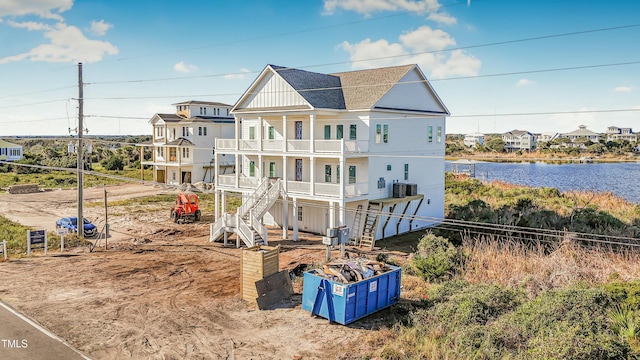 rear view of house with a water view and a balcony