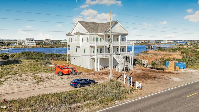 view of front of house with a water view and a balcony