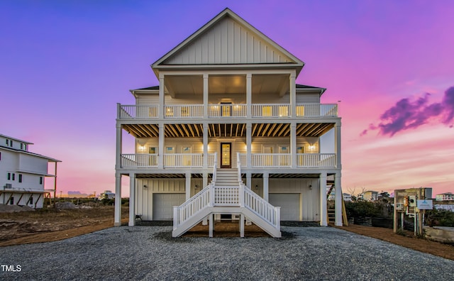 beach home featuring a garage, a balcony, and a porch