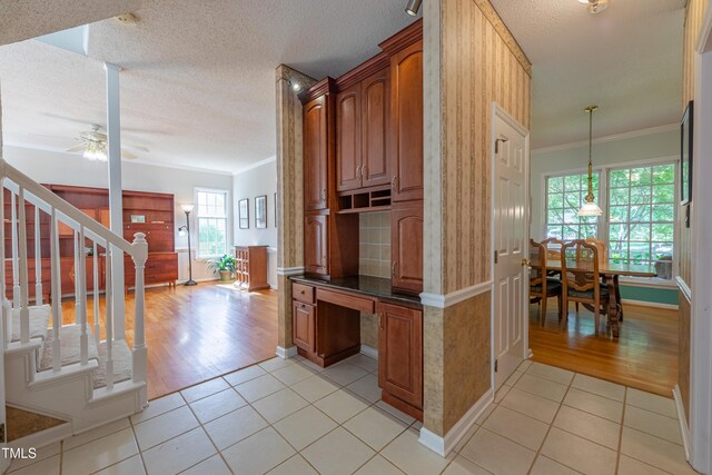 hall featuring crown molding, light tile patterned flooring, stairs, a textured ceiling, and baseboards
