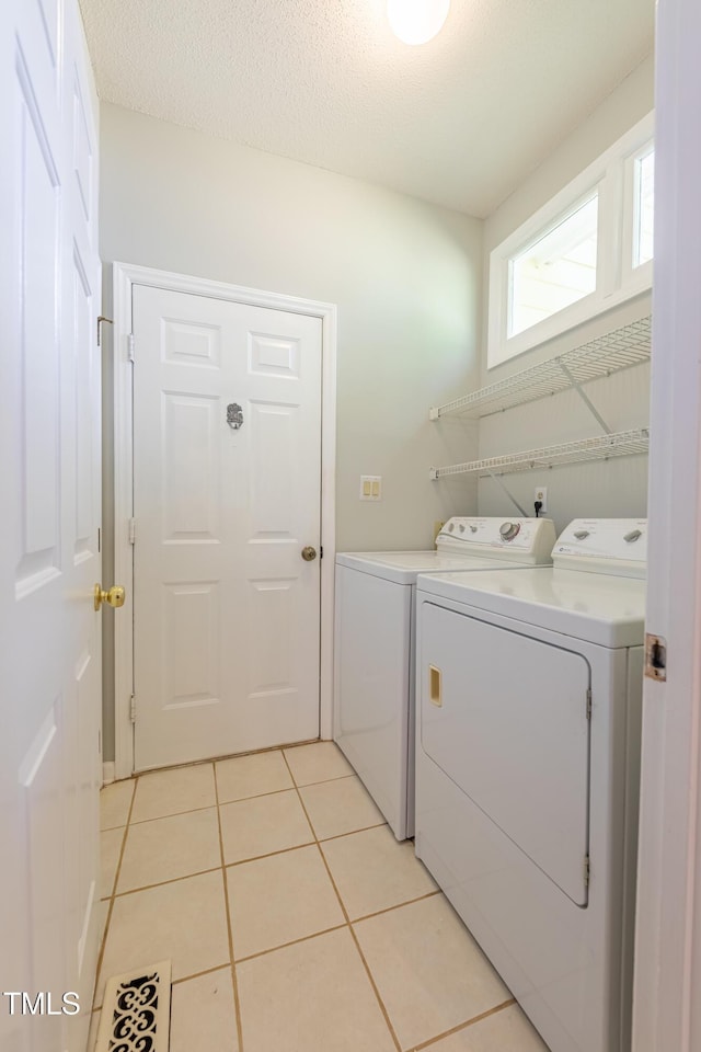 washroom featuring washing machine and clothes dryer and light tile patterned floors
