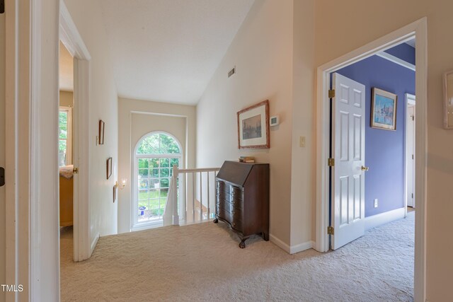 entrance foyer featuring carpet, baseboards, and vaulted ceiling
