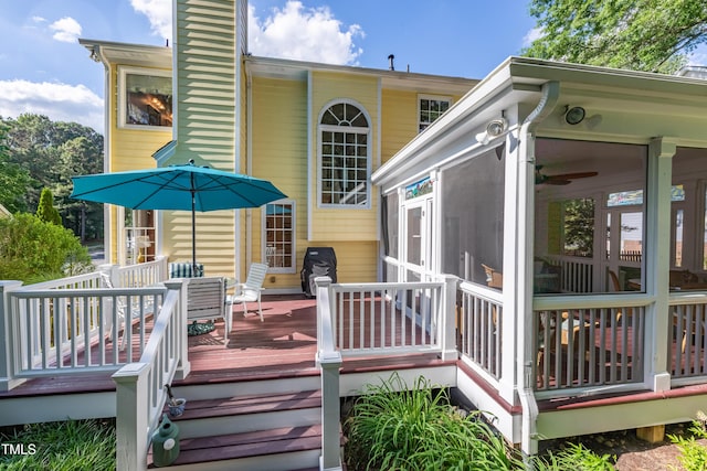 wooden terrace featuring a sunroom and area for grilling