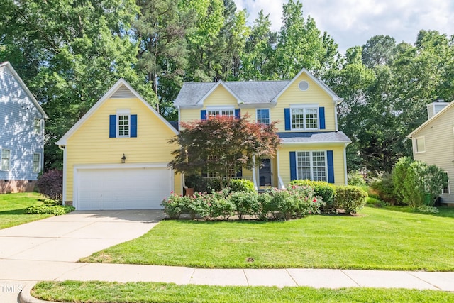 traditional home with a front lawn, concrete driveway, and an attached garage