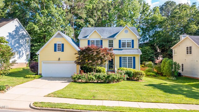 traditional-style house featuring an attached garage, concrete driveway, and a front yard