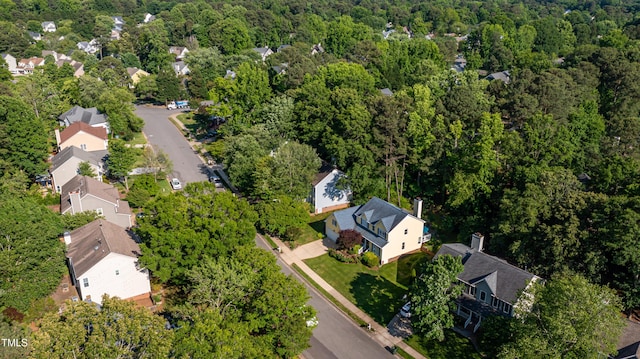 view of property location with a heavily wooded area and nearby suburban area