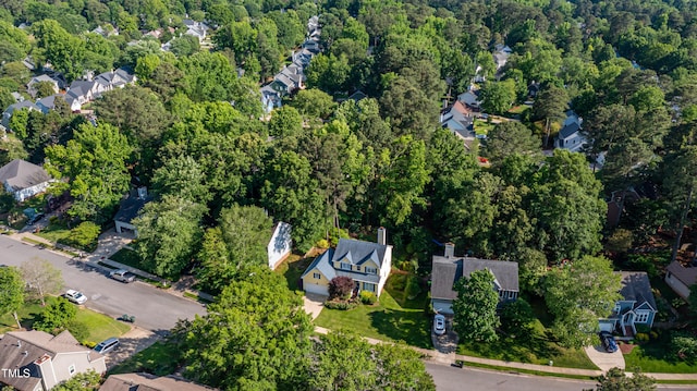 view of property location featuring nearby suburban area and a heavily wooded area