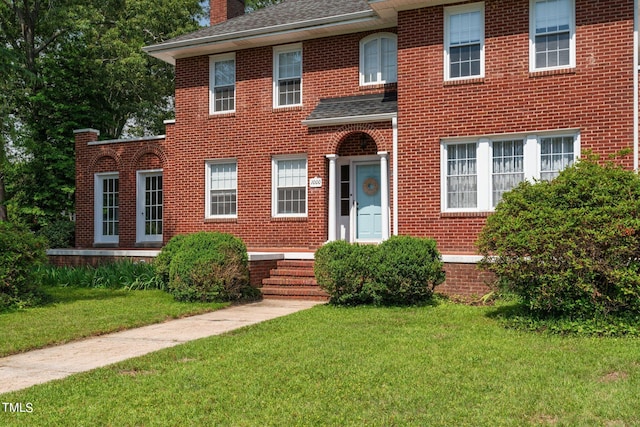 colonial home featuring a front lawn