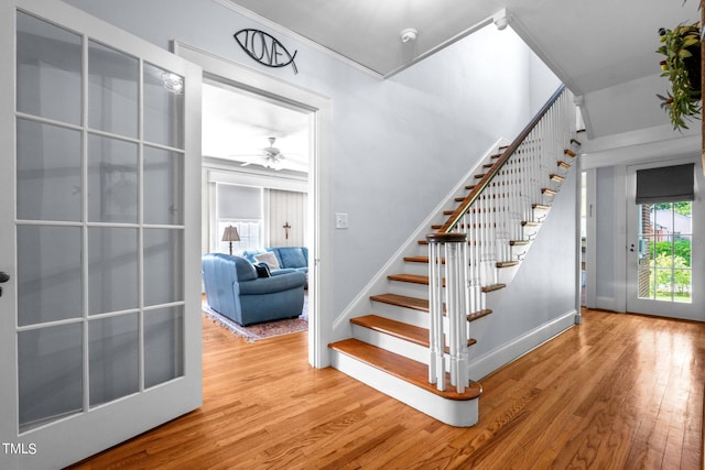 stairway featuring ceiling fan and light wood-type flooring