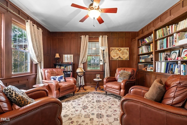 living room with wooden walls and ceiling fan