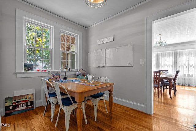 dining area with light hardwood / wood-style flooring and an inviting chandelier