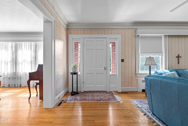 entrance foyer with light hardwood / wood-style flooring, radiator, and crown molding