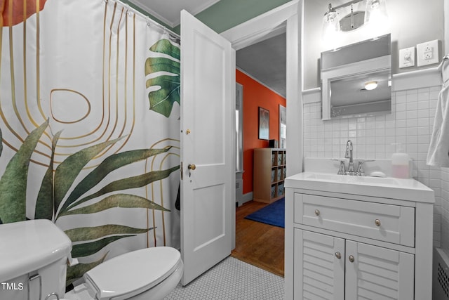 bathroom featuring crown molding, tile flooring, tile walls, large vanity, and toilet