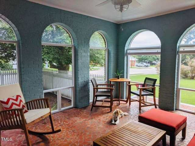 sunroom / solarium with a healthy amount of sunlight and ceiling fan