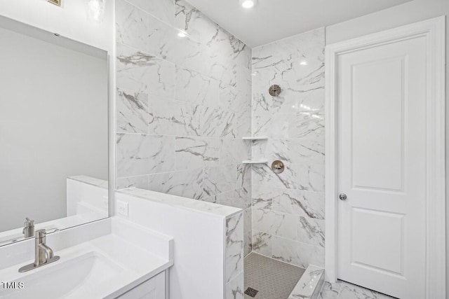 bathroom with vanity and a tile shower