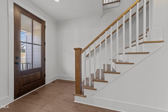 foyer with hardwood / wood-style floors and ornamental molding