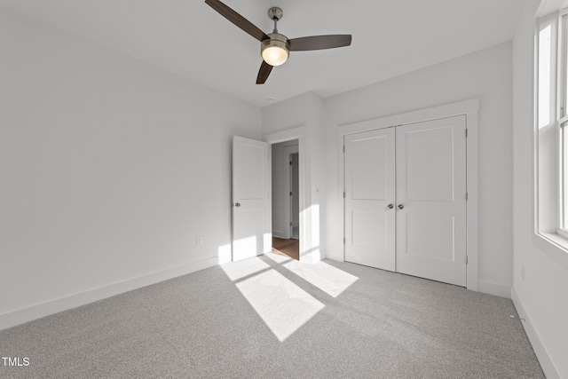 unfurnished bedroom featuring light carpet, a closet, and ceiling fan