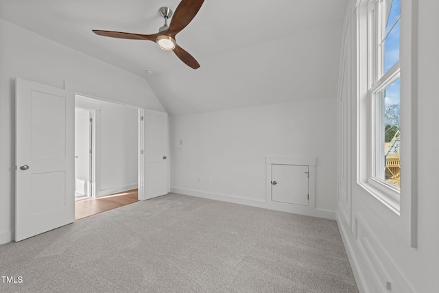 additional living space featuring ceiling fan, light colored carpet, and lofted ceiling