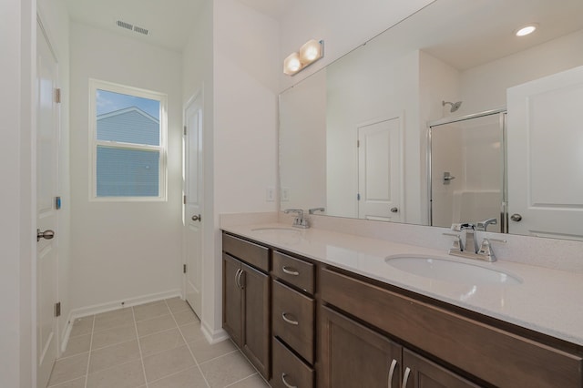 bathroom featuring tile patterned flooring, a shower with shower door, and vanity