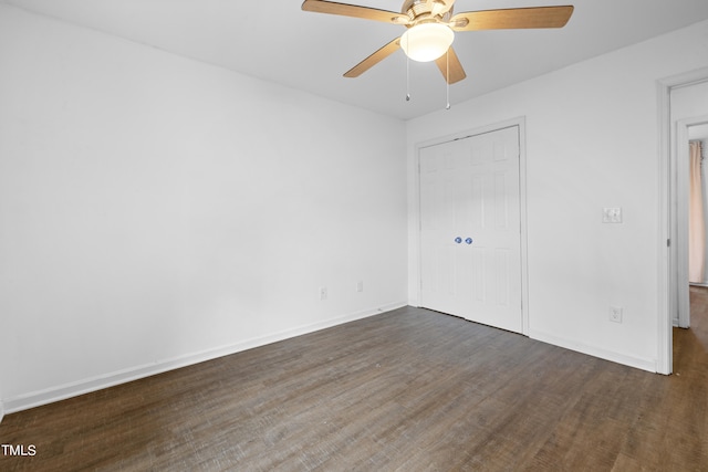 unfurnished bedroom with ceiling fan, dark wood-type flooring, and a closet