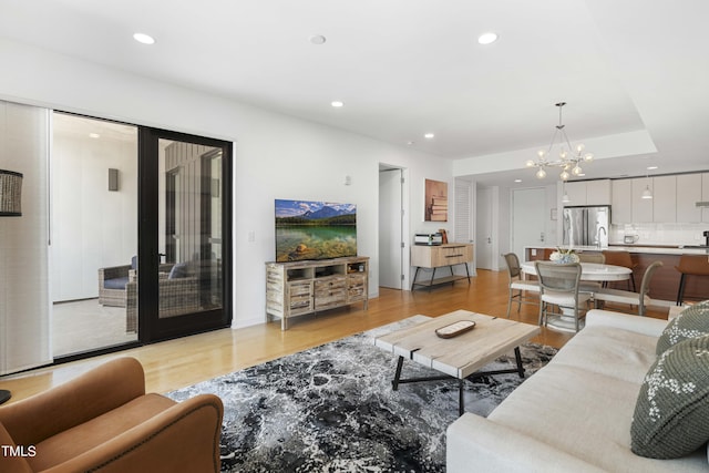 living room featuring a chandelier and light hardwood / wood-style flooring