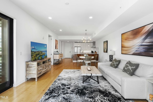 living room with an inviting chandelier and light hardwood / wood-style flooring