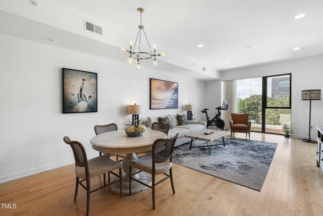 dining room featuring a notable chandelier and light wood-type flooring