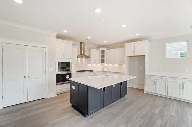 2023 Seneca Dr Lot 32, Raleigh, NC 27604 - kitchen with wall chimney range hood, oven, white cabinetry, and a kitchen island with sink