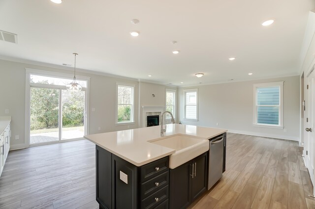 2023 Seneca Dr Lot 32, Raleigh, NC 27604 - kitchen featuring dishwasher, crown molding, an island with sink, light wood-type flooring, and sink
