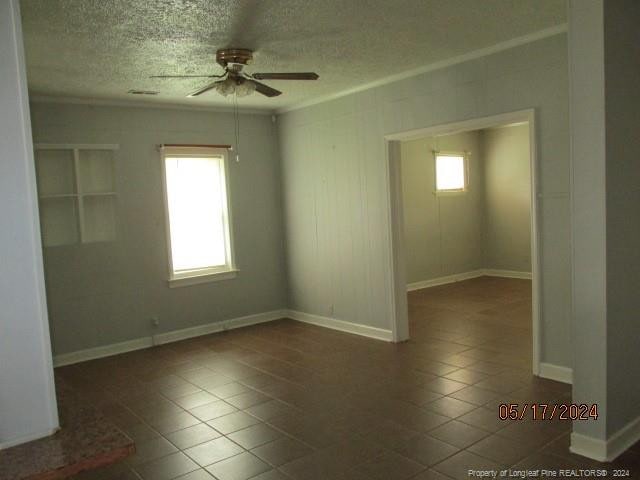 607 Carthage Rd, Lumberton, NC 28358 - unfurnished room with dark tile flooring, ceiling fan, and a textured ceiling