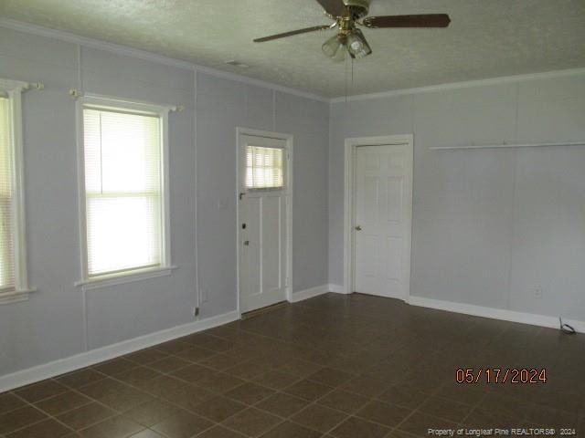 607 Carthage Rd, Lumberton, NC 28358 - unfurnished room with plenty of natural light, ceiling fan, and dark tile flooring