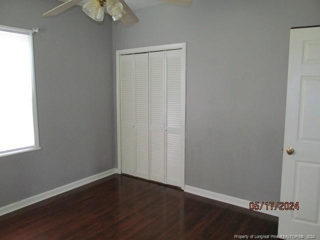 607 Carthage Rd, Lumberton, NC 28358 - unfurnished bedroom with a closet, ceiling fan, and dark hardwood / wood-style flooring