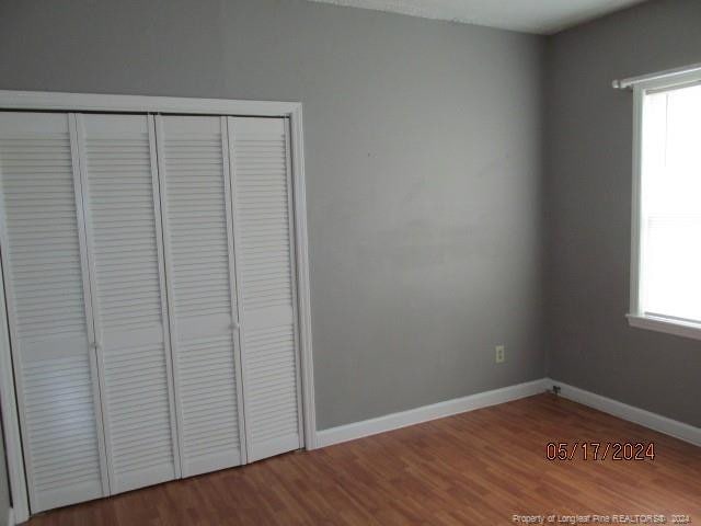 607 Carthage Rd, Lumberton, NC 28358 - unfurnished bedroom featuring wood-type flooring, a closet, and multiple windows