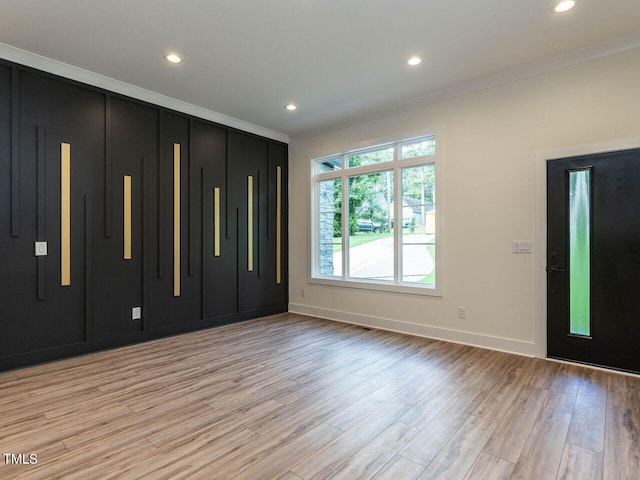 foyer featuring ornamental molding and light wood-type flooring